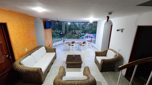 a living room with couches and chairs and a table at Finca Casa Real la Vega in La Vega