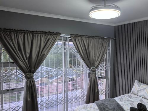 a bedroom with a bed and a large window at 1 at Gurnard in Newlands