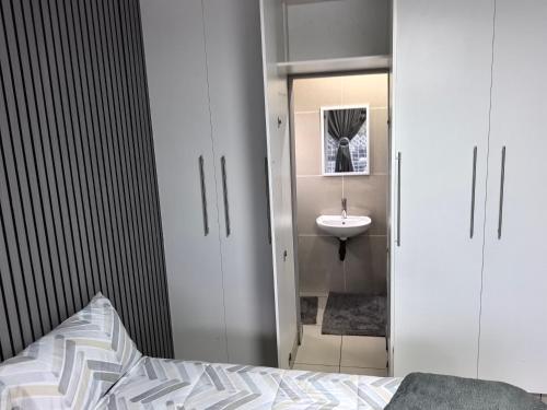 a bathroom with a bed and a sink and a mirror at 1 at Gurnard in Newlands