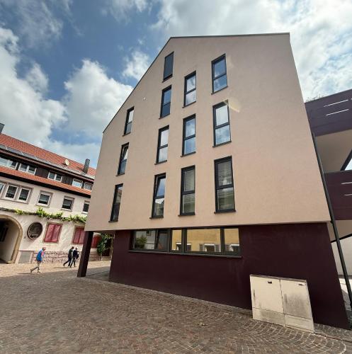 a building on a street with people walking at Sali Homes Apartmenthaus Schlossgasse in Neckarsulm