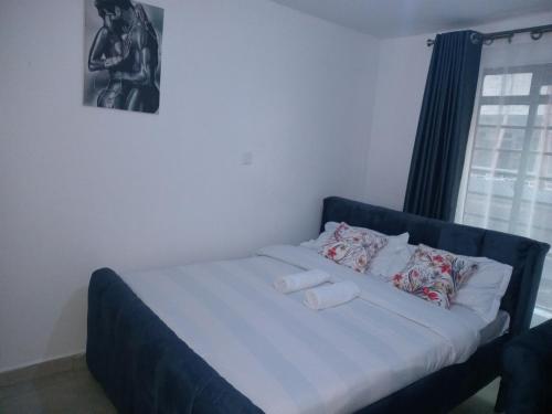 a bed with two pillows on it in a bedroom at Cavendish Square Studio Unit, Syokimau in Syokimau
