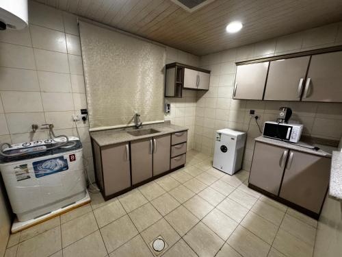 une petite cuisine avec un évier et une cuisinière dans l'établissement راكة سويت 1, à Khobar