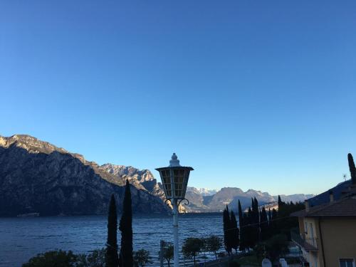 a street light with a view of the water and mountains at Hotel Vela Azzurra in Malcesine
