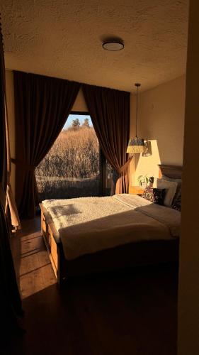 a bedroom with a bed with a view of a field at Shalash 2 in Velikiye Lazy
