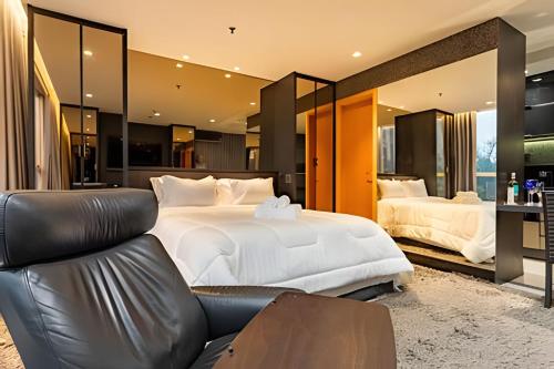 a bedroom with two beds and a leather couch at Flat moderno Jade hotel in Brasília