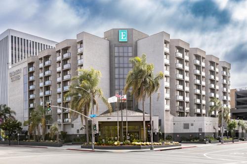 a large hotel with palm trees in front of it at Embassy Suites Los Angeles - International Airport/North in Los Angeles