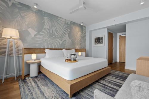 a bedroom with a large white bed and a couch at Park Central South Beach in Miami Beach