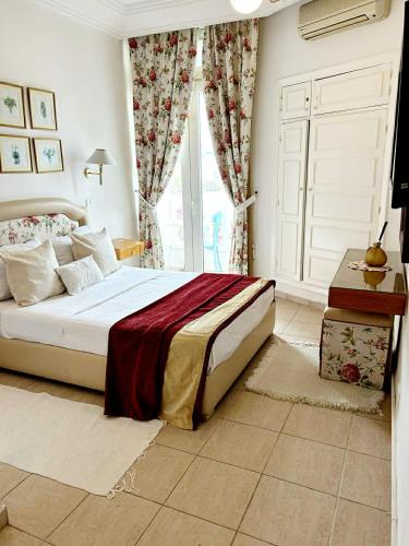 a bedroom with a bed and a large window at Hotel Plaza la marsa in Tunis