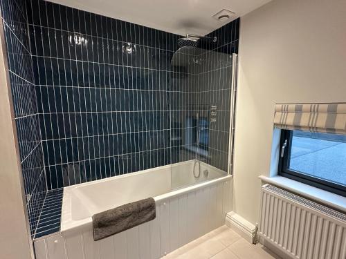 a bathroom with a bath tub and a window at East Barn Bed & Breakfast in Wall