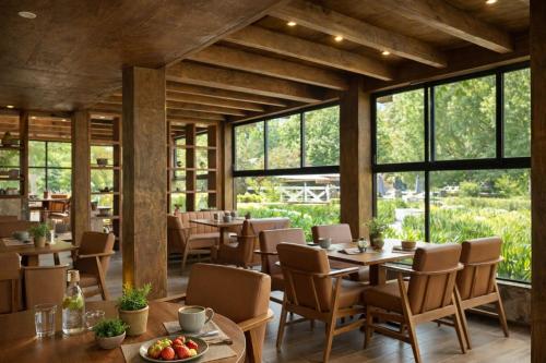 a restaurant with tables and chairs and large windows at Orgánico Hotel Boutique in Mexico City