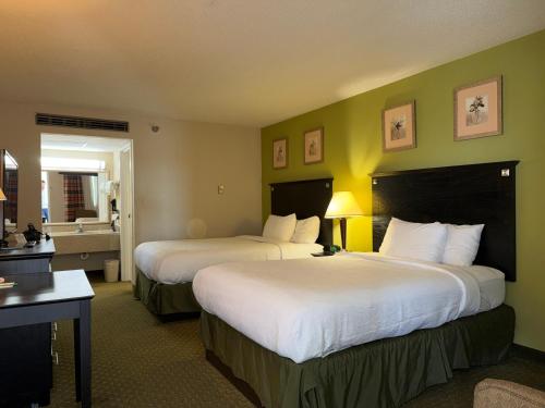 a hotel room with two beds and a bathroom at Quality Inn & Suites Moline Airport in Moline