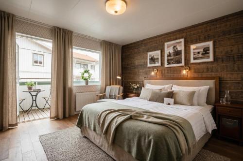 a bedroom with a large bed and a balcony at Ekenäs Havshotell Koster in Sydkoster