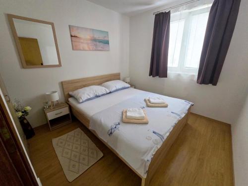 a bedroom with a bed with two towels on it at Apartman Jadranka in Vir