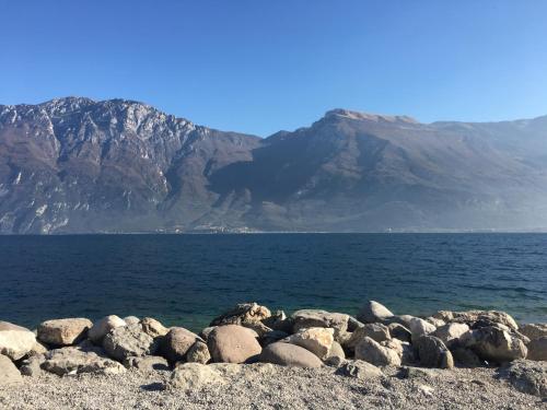 a group of rocks on the shore of a body of water at Hotel Vela Azzurra in Malcesine