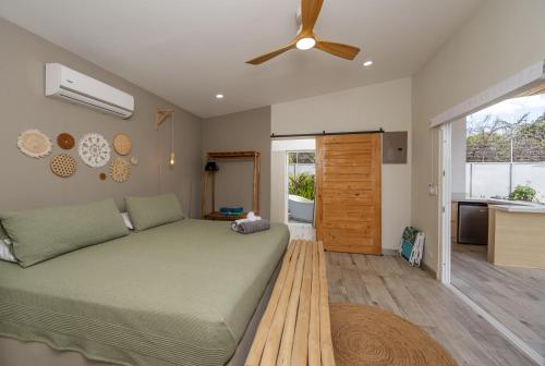 a bedroom with a bed and a ceiling fan at Antemar Guest, Beach bungalow near Conchal in Brasilito