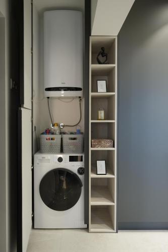 a laundry room with a washing machine and a shelf at Djuric Apartmani in Zaječar