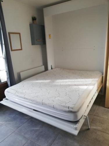 un lit dans une chambre avec un matelas blanc dans l'établissement JUNO, à Courseulles-sur-Mer