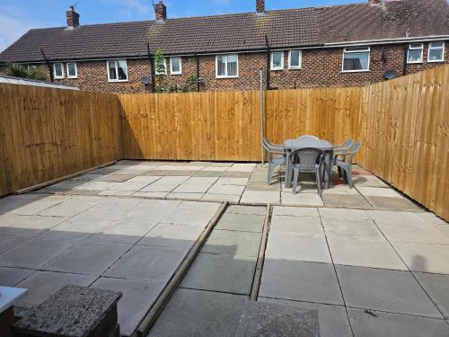 a patio with a table and a fence at Leasowe House in Bidston