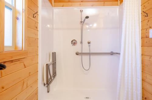 a shower in a bathroom with a shower curtain at Yosemite Lakes Cabin & Cottages in Harden Flat