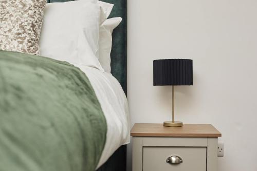 a bedroom with a bed with a lamp on a night stand at Hayy Studios at Castleford in Castleford