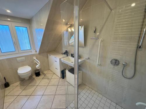 a bathroom with a shower and a toilet and a sink at Küstenbude Ostseestübchen in Grömitz