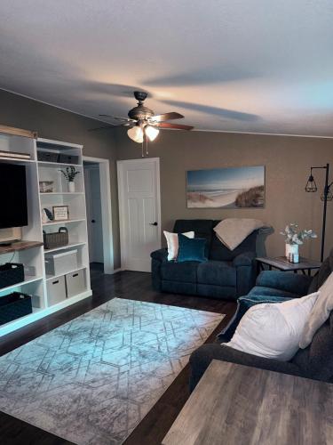 a living room with a couch and a ceiling fan at Sugar Maple Getaway in Gaylord