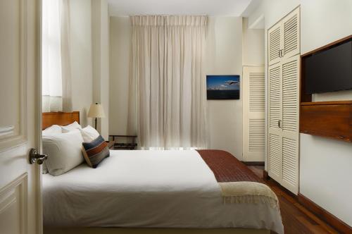 Un dormitorio con una cama grande y un televisor. en Las Clementinas, en Panamá