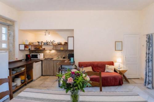 a living room with a red couch and a kitchen at La Familiale, Aile du Château de Busqueilles à Autoire, 3 chambres, 3 SDB, vue parc & calme in Autoire
