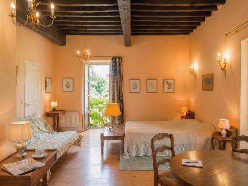 a living room with a bed and a table at La Familiale, Aile du Château de Busqueilles à Autoire, 3 chambres, 3 SDB, vue parc & calme in Autoire