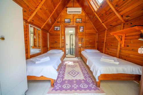 a bedroom with two beds in a wooden cabin at Olympos Mocamp in Kaş