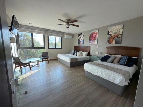 a bedroom with two beds and a table at Casa Arandas Hotel - Suits in Arandas