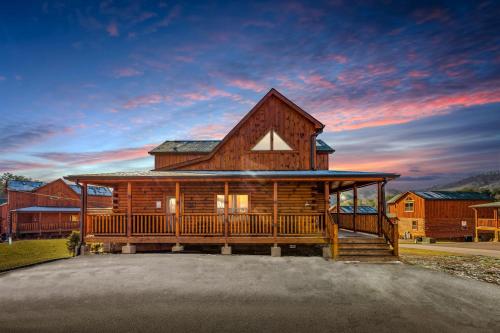 a large log cabin with a large deck at Indoor Pvt Pool, Pkyway, 44, HotTub, BBQ, King in Pigeon Forge