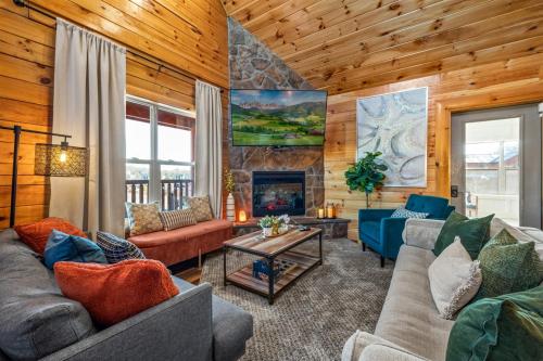 a living room with couches and a fireplace at Indoor Pvt Pool, Pkyway, 44, HotTub, BBQ, King in Pigeon Forge