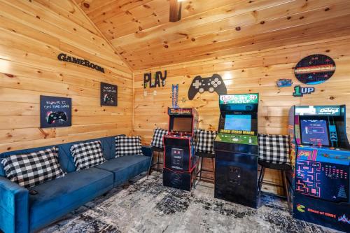 a room with a couch and four video game machines at Indoor Pvt Pool, Pkyway, 44, HotTub, BBQ, King in Pigeon Forge