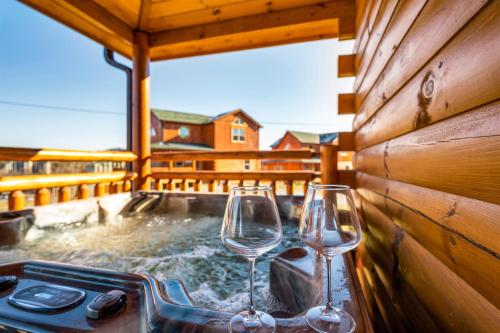 two wine glasses in a hot tub on a deck at Indoor Pvt Pool, Pkyway, 44, HotTub, BBQ, King in Pigeon Forge