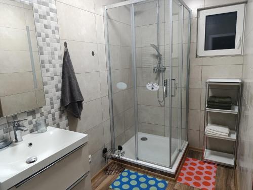 a bathroom with a glass shower and a sink at DOMA Les in Včelná