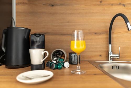 a kitchen counter with a sink and a glass of orange juice at Apartmani Opg Dragoslavić in Stari Vas