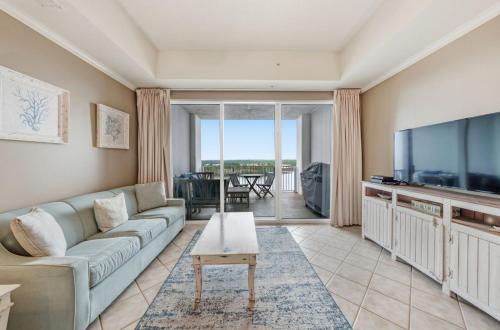 a living room with a couch and a flat screen tv at Wharf 615 by Youngs Suncoast in Orange Beach