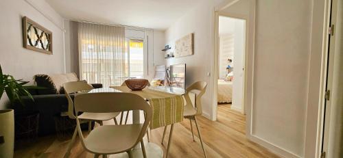 a dining room and living room with a table and chairs at Residencial Colibrí in Cambrils