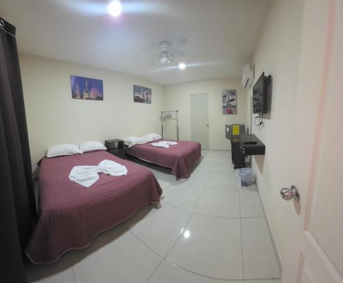 a room with two beds and a sink in it at Hotel Mexico in Cancún