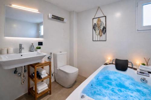 a bathroom with a blue bath tub next to a sink at Apartamentos De la Haya & Suite con Jacuzzi, junto al Teatro Romano in Mérida