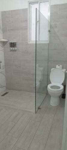 a white bathroom with a toilet and a window at Apartamento-2B-Zona-Colonial in Santo Domingo