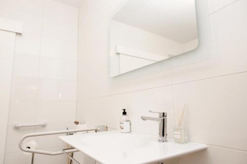 a white bathroom with a sink and a mirror at Loft Valentia Ifach Calpe in Calpe