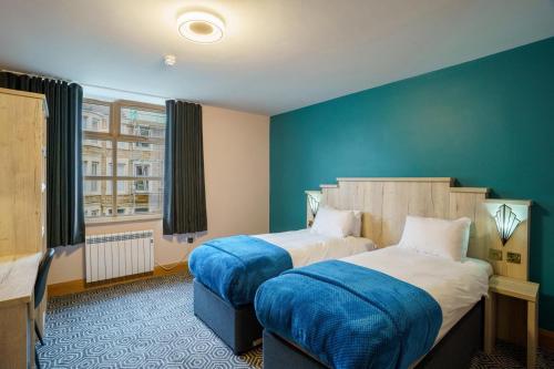 a hotel room with two beds and a window at The Bath Rooms in Morecambe