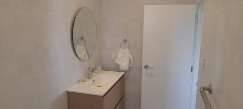 a white bathroom with a sink and a mirror at Reureu Ocean Vistas in Arutanga