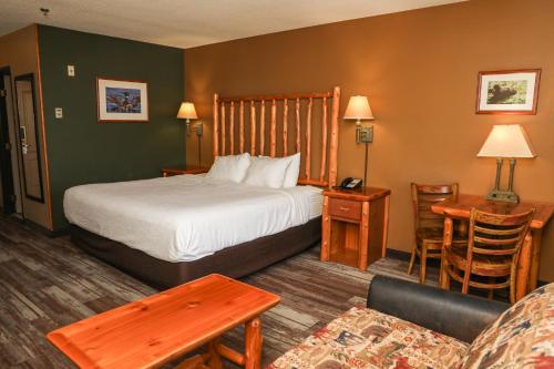 a hotel room with a bed and a couch at Grand Ely Lodge in Ely