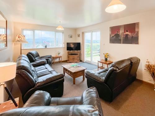 a living room with leather furniture and a tv at Uk47550 - Cairnsmore Cottage in Newton Stewart