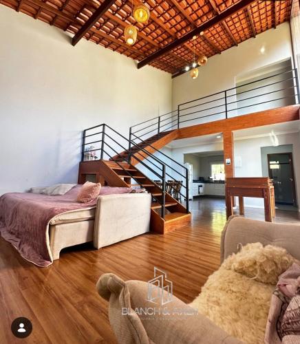 a living room with a bed and a staircase at Casa 3 Quartos Recanto Buritis in Santa Teresa