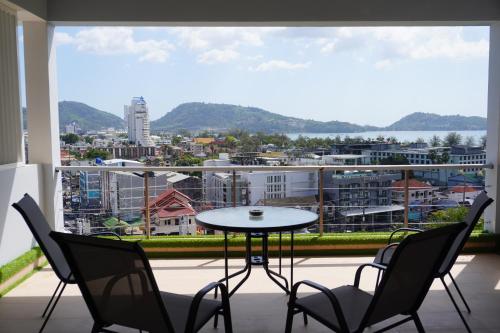 a table and chairs in front of a large window at Bayview Villa by AaskResidy in Patong Beach