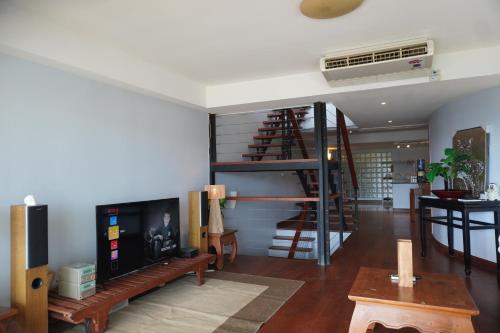 a living room with a spiral staircase in a house at Bayview Villa by AaskResidy in Patong Beach